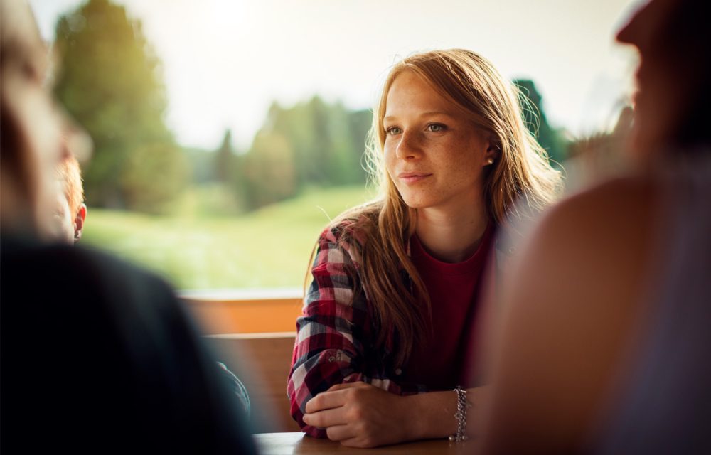 Nuori tytto keskustelee vanhempiensa kanssa
