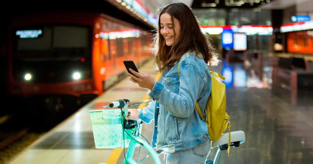 Tyttö odottaa metroasemalla pyörän kanssa.