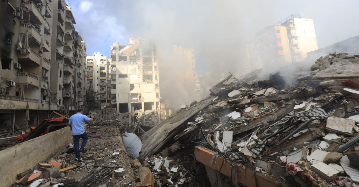 LEBANON - ISRAEL - PALESTINIAN - CONFLICT TOPSHOT - A man takes pictures of smoke seeping from the building rubble at the site of an overnight Israeli airstrike on the Laylaki neighbourhood in Beirut's southern suburbs on October 1, 2024. Israeli strikes on Lebanon killed 95 people on September 30, according to Lebanon's health ministry. (Photo by AFP), AFP / LEHTIKUVA