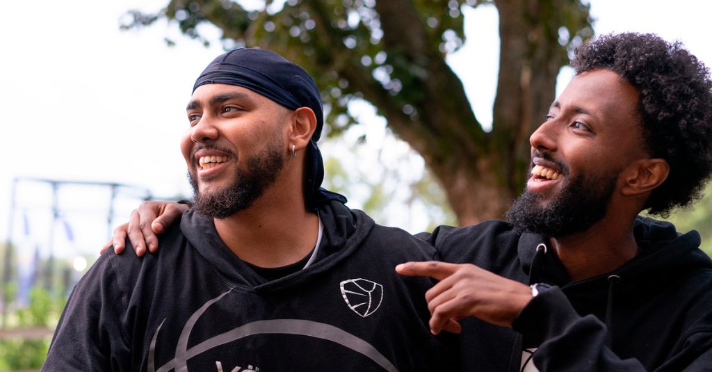 Kaksi yökoris-toiminnassa mukana olevaa nuorta hymyilee.